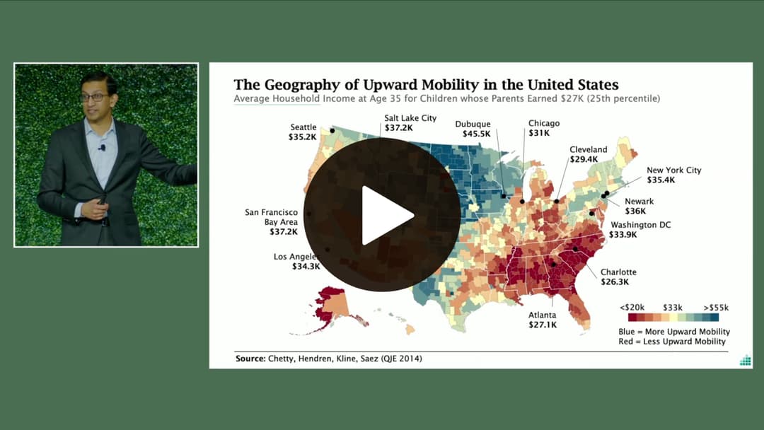 The presenter stands beside a map of the U.S. showing upward mobility by region, with varying colors indicating different income levels.