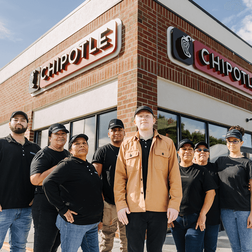 Chipotle employees in front of a storefront